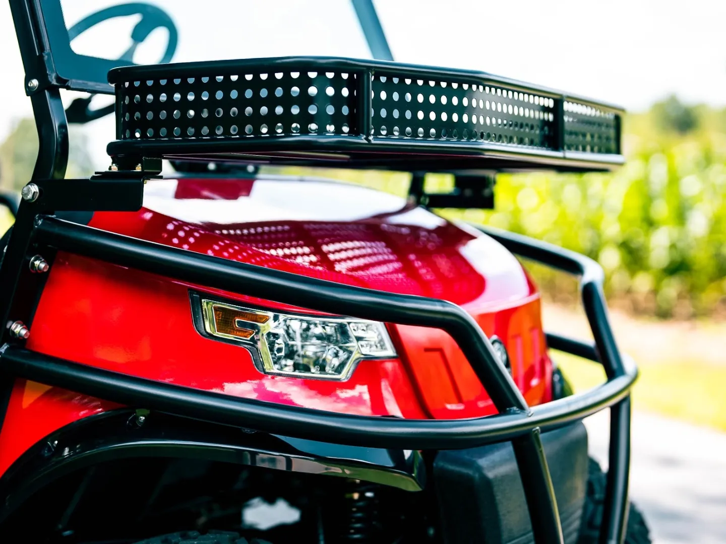 Front-end detail of a red Redline golf cart's grille guard and cargo basket